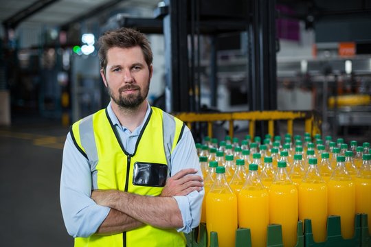 Portrait of factory worker standing with arms crossed