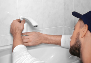 Wall Mural - Closeup of plumber fixing tap on sink