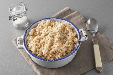 Wall Mural - Bowl with brown rice on gray table