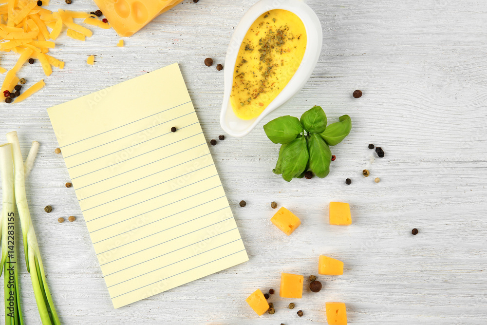 Still life with food ingredients and blank paper on table