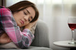 © Africa Studio - Young depressed woman on bed and wine on table indoors