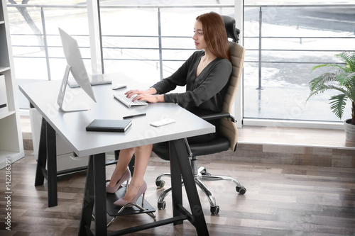 Fotomural Posture concept. Young woman working with computer at office