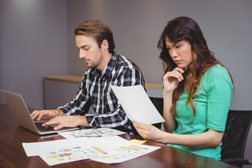 Wall Mural - Male and graphic designers working together in conference room