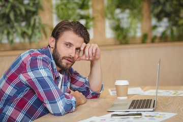 Wall Mural - Portrait of tensed business executive with laptop siting at desk