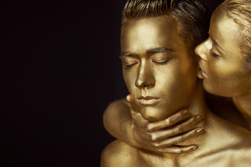  A girl and a guy covered in gold paint. With my eyes closed.The girl leaned in and kisses his ear