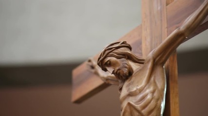 Wall Mural - the camera horizontally moves from left to right framing a wooden statue of Jesus Christ on the Cross