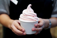 Closeup of woman 's hand holding takeaway cup with organic frozen yogurt ice cream, It's delicious and healthy enjoy eating concept.