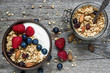 homemade granola with greek yogurt, nuts and fresh berries in a bowl