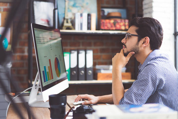 Asian men is watching a graph from a computer in the office.