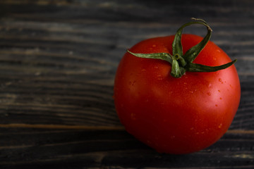 Tomato on a wooden background in rustic style