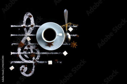 Zdjęcie XXL Pojęcie filiżanka kawy na czarnym tle z pikantność i cukierem