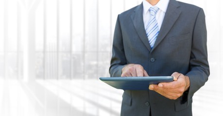 Poster - Business man mid section with tablet against blurry window