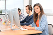 © W PRODUCTION - group of young people telephone operator with headset working on desktop computer in row in customer service call support helpline business center