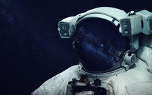Astronaut At Spacewalk. Cosmic Art, Science Fiction Wallpaper. Reflection In Spacesuit Vizor. Billions Of Galaxies In The Universe. Elements Of This Image Furnished By NASA