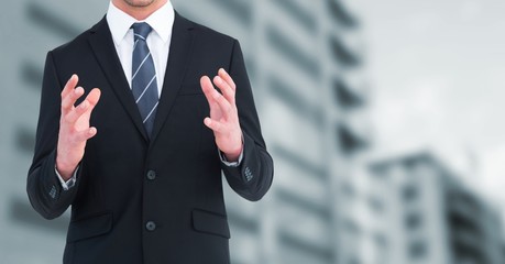 Poster - Business man mid section with hands up against blurry building