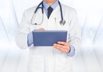 Poster - Doctor mid section with tablet against blurry window