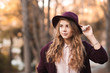 © morrowlight - Stylish blonde teen girl 14-16 year old wearing purple hat and jacket in park. Posing outdoors. Looking away.