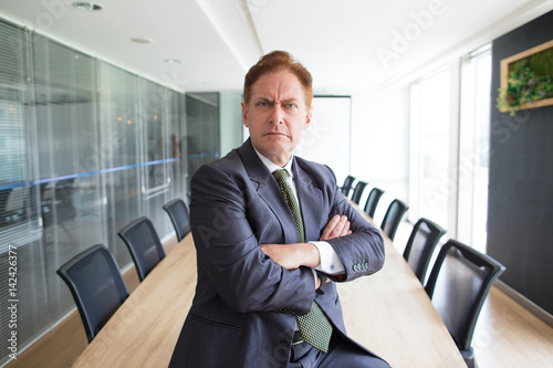 Fotomural Portrait of stern senior businessman in boardroom
