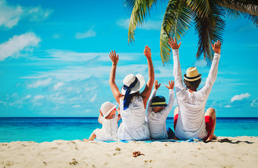 happy family with two kids hands up on beach