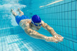 Schwimmer gleitet nach Startsprung unter Wasser