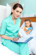 © LIGHTFIELD STUDIOS - Woman doctor writing in clipboard diagnosis of sick little girl