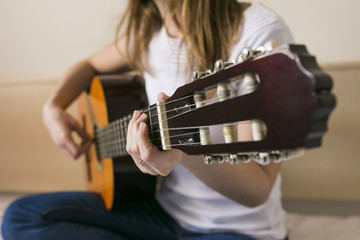 Closeup image of guitar in caucasian woman hands