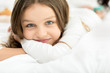 © LIGHTFIELD STUDIOS - little adorable girl lying and relaxing on bed at home, looking at camera
