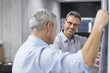 © Westend61 - Two businessmen discussing construction plan at concrete wall