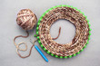 © Olvita - Process of knitting a scarf-snod from a soft thick Melange yarn semi-wool on a circular loom machine
