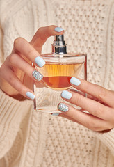 Fotomurales - Beautiful perfume bottle in woman's hands.