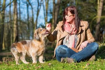 Wall Mural - young woman gives her dog a treat