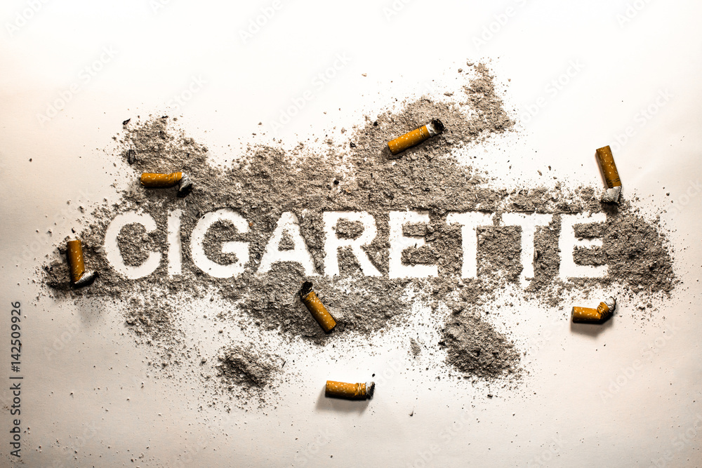 Cigarette word text written in ash filth or dirt with cigarette butts  around as smoking passion, health danger, nicotine lust, sickness and  illness concept background Stock Photo