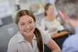 Smiling lady at desk opposite spectacled man