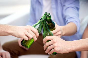 Poster - close up of friends clinking beer bottles at home