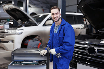 Wall Mural - Young mechanic with tools in car service