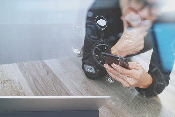 Businessman hand using mobile payments online shopping,omni channel,in modern office wooden desk,icons graphic interface screen,eyeglass