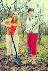 women planting tree at orchard