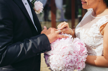 The bride puts on the engagement ring to the groom