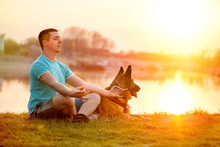 Relaxed Man And Dog Enjoying Summer Sunset Or Sunrise