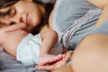 Wall Mural - Mother with newborn baby on the bed at home.