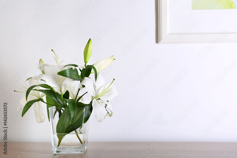 Beautiful white lilies in vase on table