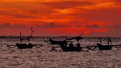 Wall Mural - Black silhouettes of fishing boats at beautiful orange sunset in bali island