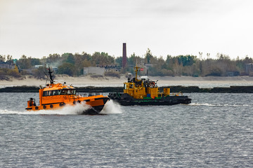 Sticker - Orange pilot ship moving at speed past the tug ship in Riga