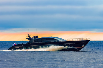 Wall Mural - Black elite speed motor boat moving fast from Baltic sea