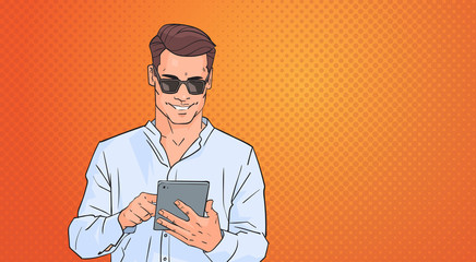 Poster - young man using tablet computer networking online over pop art colorful retro style background vecto