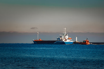 Blue cargo ship leaving Riga and entering Baltic sea