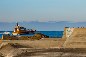 Sticker - Yellow pilot ship moving at speed past the breakwater dam