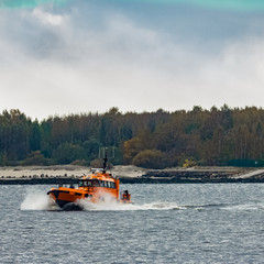 Sticker - Orange pilot ship moving at speed past the lighthouse in Riga