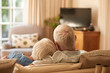 © mavoimages - Affectionate senior couple relaxing together on their sofa at home
