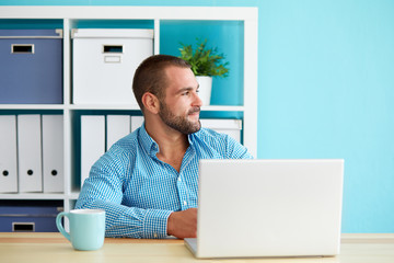 Wall Mural - Man sitting behind a desk and looking out the window